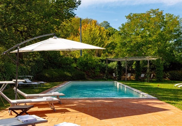 The swimming pool occupies a central place in the beautiful garden in front of the villa (umbrella no longer present) – La Tana del Ghiro