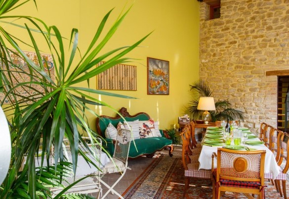 The veranda is furnished with tables, chairs and a sofa - La Tana del Ghiro
