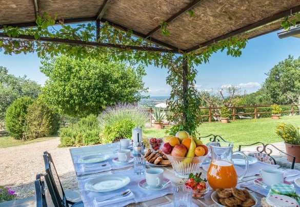 La zona pranzo esterna sotto la pergola, allestita con tavolo e sedie  - La Torretta 