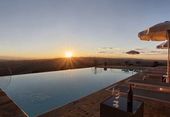La splendida piscina a sfioro di nuova costruzione si adagia sul terrazzamento inferiore del giardino e si affaccia su un paesaggio aperto e panoramico – La Vecchia Fonte