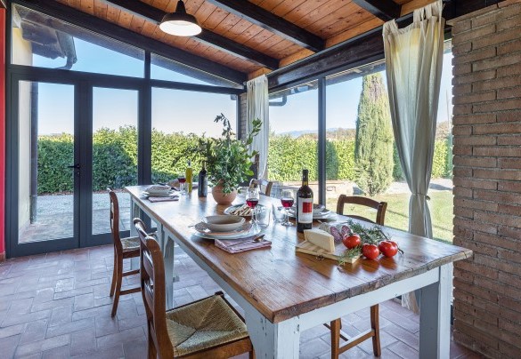 The air-conditioned veranda, set up as a living area, allows guests to enjoy pleasant meals in a cosy environment - La Vigna