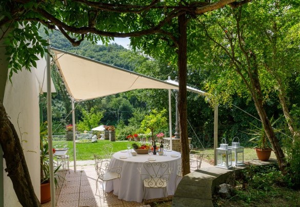 Al lato della villa una copertura crea il luogo perfetto per prazi e cene all'aperto - La villa Dina