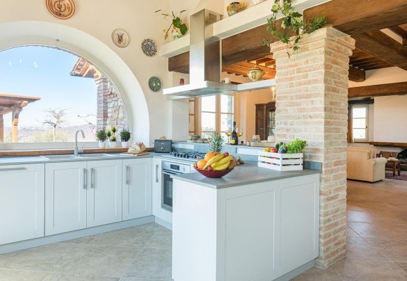 Cucina in muratura con ampio finestrone a arco con splendida vista del giardino - La Villetta di Dante