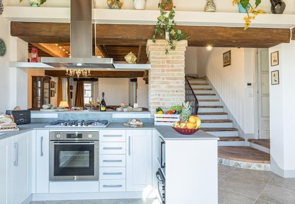 Ampia cucina attrezzata con soggiorno e tavolo da pranzo, scale interne in legno che portano al piano superiore con camera matrimoniale e bagno privato - La Villetta di Dante