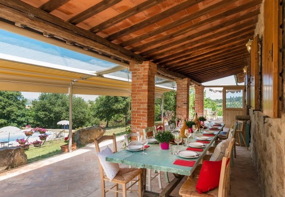 Il portico panoramico in legno fronte piscina, arredato con living ed area pranzo - Le Bandite 