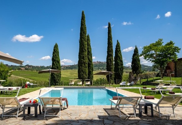 ll solarium in pietra circondato da prato ospita lettini, ombrelloni, tavolini e un gazebo con salotto all’aperto - Le Colombelline