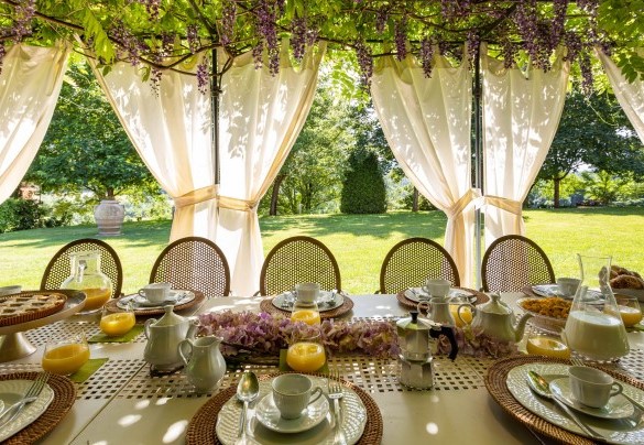 La graziosa pergola con il tavolo preparato per mangiare all'aperto - Le Querce dei Medici  