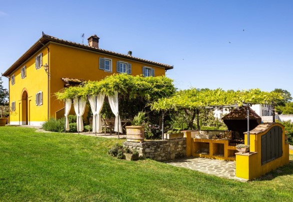 Il barbecue in muratura e il tavolo esterno adiacente alla cucina - Le Querce dei Medici   