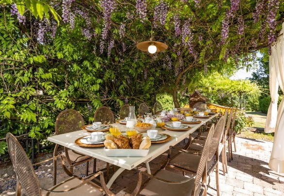 La graziosa pergola con il tavolo preparato per mangiare all'aperto - Le Querce dei Medici  