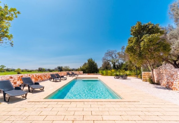 The stone sun terrace equipped with sun loungers and a parasol - Masseria Grotta Antica