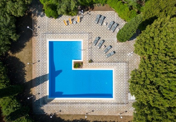 Piscina circondata da alberi e piante molto curate e completamente recintata – Masseria Profilo