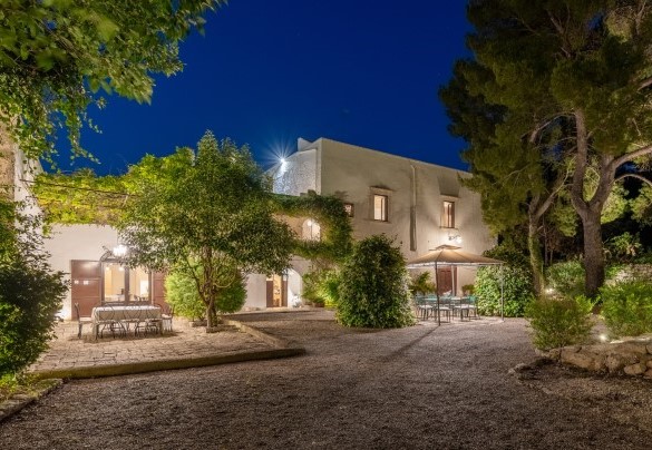 The area in front of the entrance to the house is equipped with a gazebo and table, surrounded by colourful plants and flowers – Masseria Tarsia Incuria