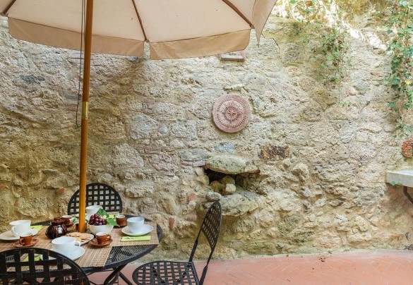 The functional outdoor dining area with table and umbrella – Mulino della Quercia 2+1