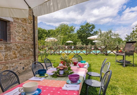 The umbrella shades the table prepared for pleasant outdoor breakfast – Podere Bagnolo 8