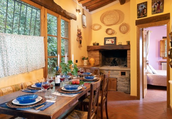 Tavolo da pranzo, caminetto e porta per uscire sul retro della villa – Podere Belvedere
