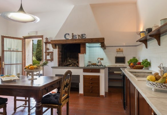 La cucina dallo stile rustico con camino - Podere Calcheto