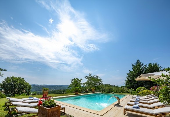 The pool features a submerged bench seat and a water cascade - Podere Casanovina
