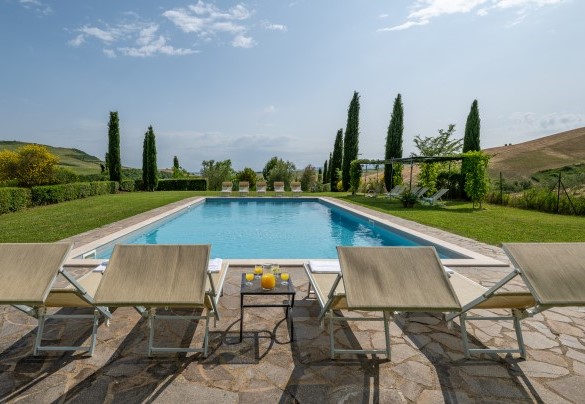 Una larga superficie in pietra di porfido circonda la piscina - Podere Collelungo