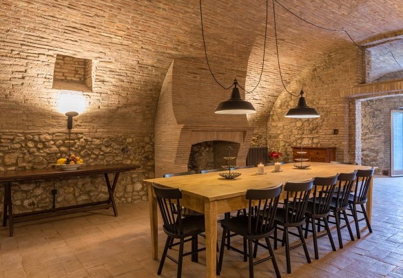 Living room with fireplace, large table and chairs on the basement - Podere Fabbrica