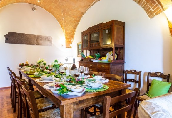 Il living con la tavola imbandita e area salotto – Podere Fornacchia 