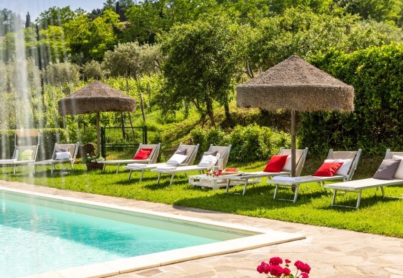 Nel prato che cinge la piscina ci sono ombrelloni, tavolini, lettini e due docce con acqua fredda – Podere Fornacchia 
