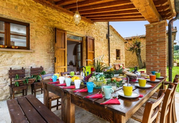 Il portico ombreggia il tavolo preparato per colazioni all’aperto – Podere Fornacchia 