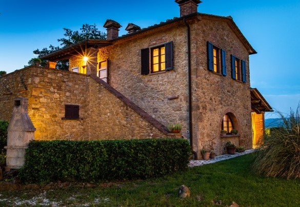 La villa avvolta da luci dai toni caldi e soffusi – Podere Fornacchia 