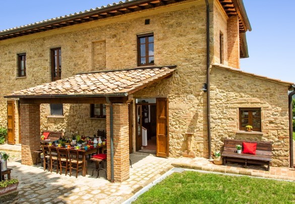 Il portico per mangiare all’aperto sullo sfondo del bucolico paesaggio che circonda la proprietà – Podere Fornacchia 