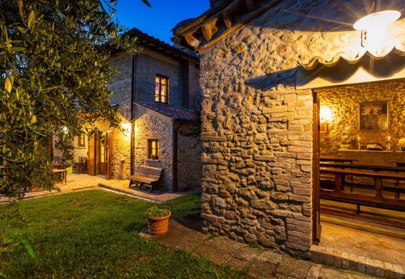 La villa avvolta da luci dai toni caldi e soffusi – Podere Fornacchia 