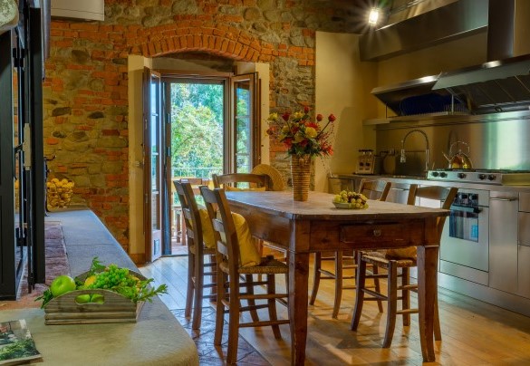 The kitchen with fireplace and terrace overlooking the pool, first floor main building - Podere Giardino