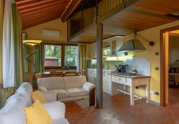 Open space con cucina e salotto con camino in appartamento 1 annesso 2 – Podere Giardino