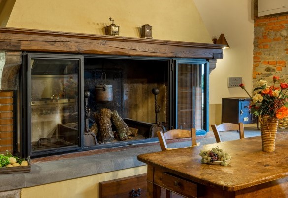 The kitchen with fireplace and terrace overlooking the pool, first floor main building - Podere Giardino