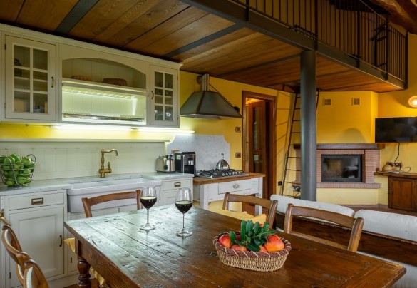 Open space con cucina e salotto con camino in appartamento 1 annesso 2