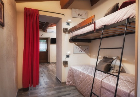 Family suite no. 4 on the first floor with a double bedroom, a separate room with two bunk beds and access to the raised floor of the external garden – Podere Il Chiesino