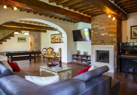Il soggiorno con caminetto ornamentale pianoforte biliardo e smart tv– Podere Montioni