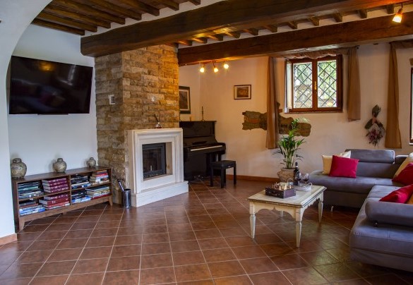 Il soggiorno con caminetto ornamentale pianoforte e smart tv– Podere Montioni