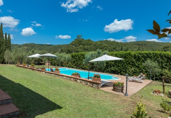 La piscina con area solarium dotata di ombrelloni e lettini – Podere Montioni