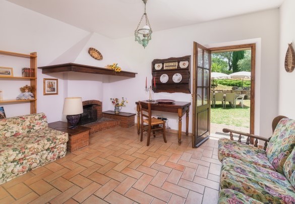 Il soggiorno a piano terra con caminetto ornamentale e con accesso all’area pranzo esterna – Podere Orcio
