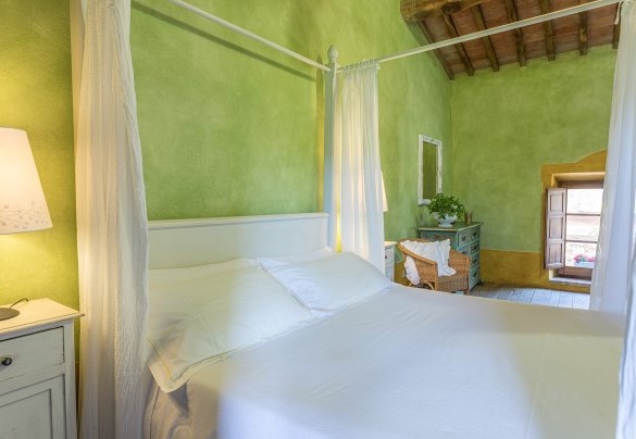 The green master bedroom with a canopy bed - Podere Pratovecchio