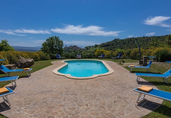 La piscina è adagiata in una felice posizione panoramica proprio di fronte al borgo di Pari – Podere San Ansano