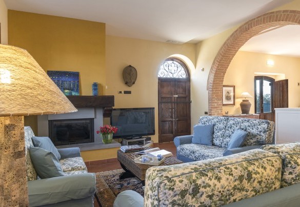 Nell’ accogliente living, dotato di aperture dirette sul giardino, organizzato con salotto, raccolto attorno ad un rustico camino – Podere Sant’Eugenio