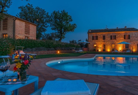 La piscina e la villa illuminati di notte - Podere Sant’Eugenio