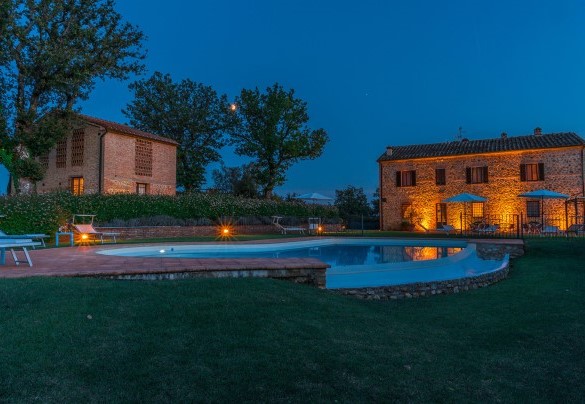 La piscina e la villa illuminati di notte - Podere Sant’Eugenio