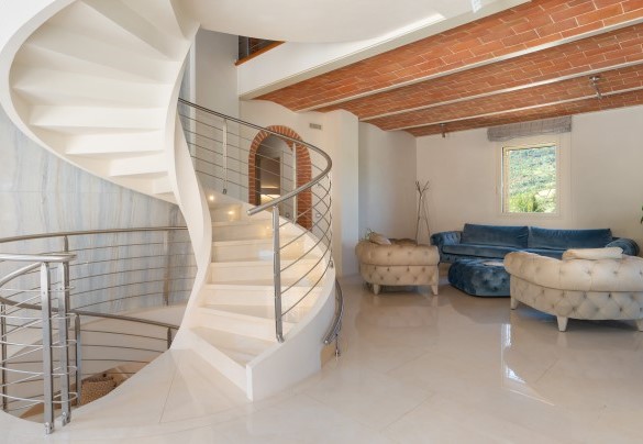 The large entrance hall and living area with a central spiral staircase on the ground floor in the main house – Podere Terranuova