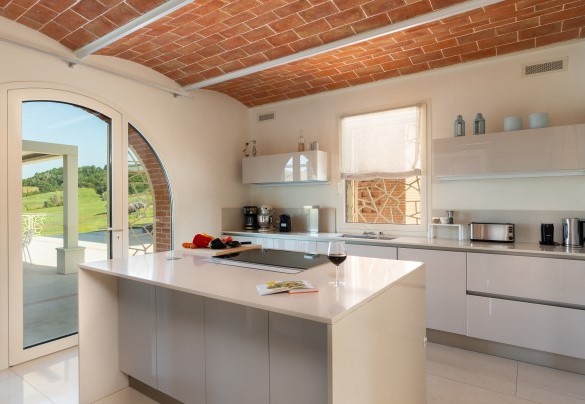 The kitchen with French windows leading out to the patio where the outdoor dining area is located – Podere Terranuova