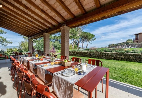 The portico in front of the living room host a table and chairs for outdoor dining - Poggio Ambrato
