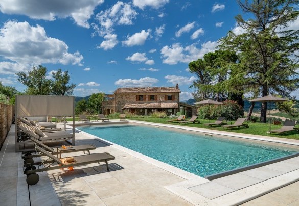 The swimming pool and the main house in the background - Poggio Ambrato