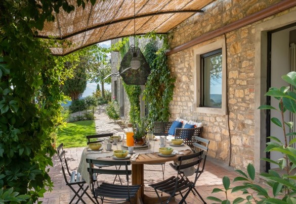 The American vine-covered pergola with table for dining in the fenced garden in front of the house entrance – Poggio Novoli