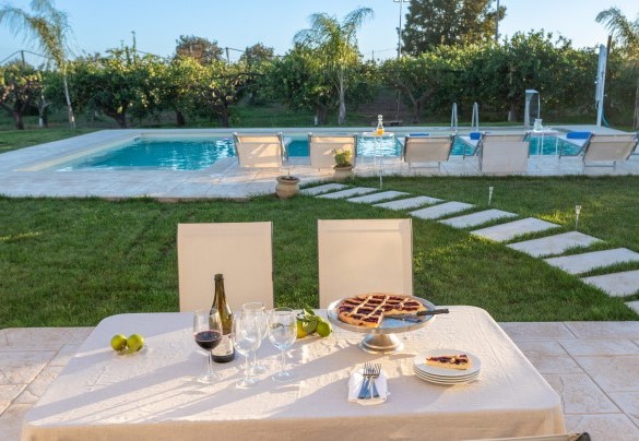 Nei pressi della piscina, uno spazio riservato all’uscita dalla villa accoglie un'area pranzo - Profumo di Zagara