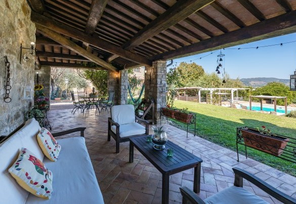 With a view towards the pool, is the large portico furnished with table, chairs, sofa and armchairs - Residenza Collefiorito